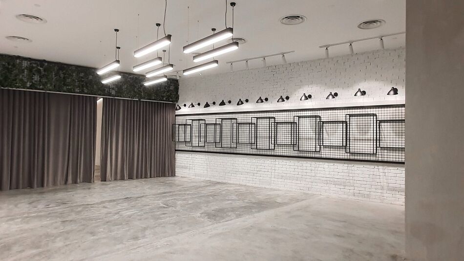 The white-brick room at The Grey Box, lit by suspended tube lights